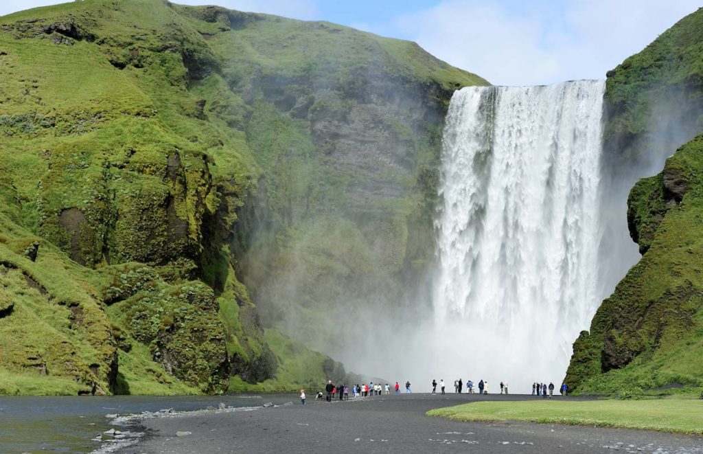 Students on an Iceland geography school trip stood under Skogafoss waterfall
