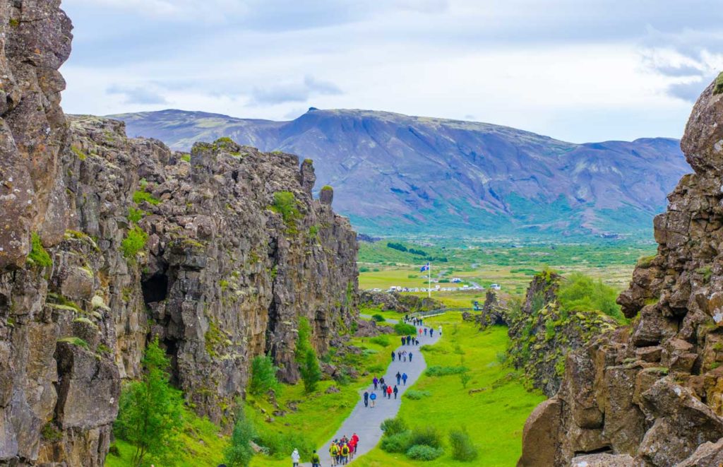 Students on a geography school trip in Thingvellir National Park in Iceland walking between the two tectonic plates