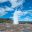 School group gathered round an erupting geysir in Iceland on a geography field trip