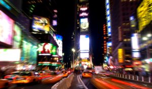 Night view of Times Square, New York City with blurred lights and yellow taxis, popular destination for educational and cultural school trips.