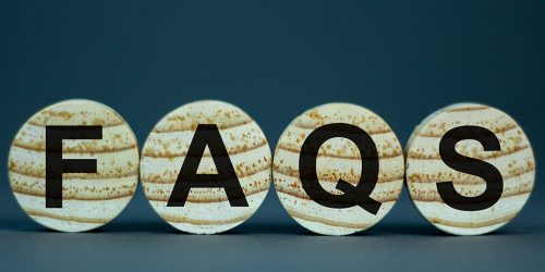 Wooden blocks spelling FAQs in black letters, frequently asked questions concept for Kipling Tours educational and cultural school trips