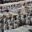 Wide-angle view of the Terracotta Army excavation site in Xi'an, China, showing rows of life-size clay soldier statues standing in earthen pits, part of the ancient burial complex for Emperor Qin Shi Huang.