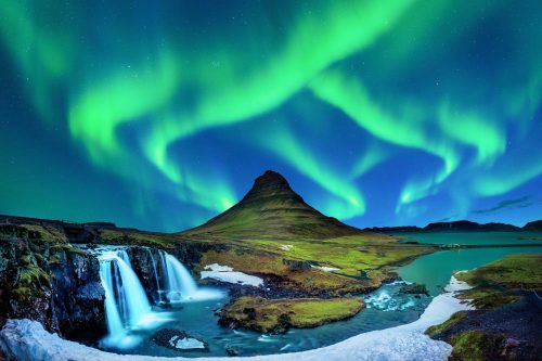 The Northern Lights above Kirkjufell mountain and waterfall in Iceland, a natural science highlight for students on a school trip studying geography, climate, and astronomy